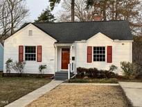 Charming home featuring a white exterior, complemented by red shutters and a inviting front yard at 2409 Shenandoah Ave, Durham, NC 27704