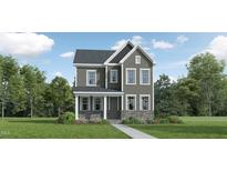 Charming two-story home with stone accents, gray siding, and lush landscaping at 344 Canyon Spring Trl, Wake Forest, NC 27587