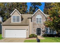 Charming two-story home featuring stone facade, attached garage, and well-maintained landscaping at 5129 Chasteal Trl, Raleigh, NC 27610
