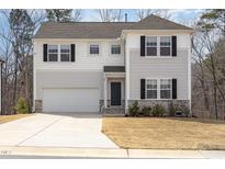 Charming two-story home with white siding, black shutters, and attached two car garage at 5439 Ripplebrook Rd, Durham, NC 27712