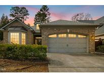 Charming brick home featuring a two-car garage, well-maintained landscaping and a beautiful sunset at 6103 Leesburg Ln, Raleigh, NC 27617