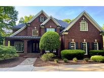 Stately brick home showcasing a manicured lawn, classic shutters and a welcoming, covered front porch at 6532 Wakefalls Dr, Wake Forest, NC 27587