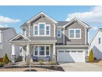 Charming two-story home with beautiful gray wood and stone accents and a welcoming front porch at 730 Tibumoll Ln, Fuquay Varina, NC 27526