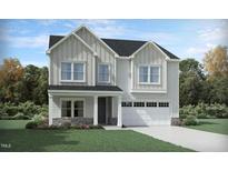 Charming two-story home featuring a two car garage, stone accents, and meticulous landscaping at 917 Thimbleweed Way, Wake Forest, NC 27587