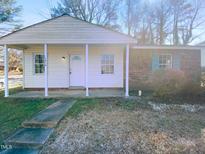 Charming single-story home featuring a covered front porch and a mix of siding and brick accents at 1216 Armstrong Cir, Raleigh, NC 27610