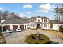 Stately home with circular driveway, water feature, attached three-car garage, and manicured landscaping at 1326 Lochshire Dr, Burlington, NC 27215