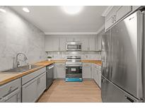 Modern kitchen features gray cabinets, stainless steel appliances, and wood countertops at 1411 Rosewood St, Durham, NC 27701