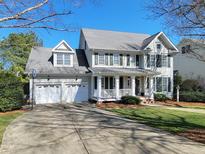 Charming two-story home featuring a welcoming front porch, attached two-car garage, and lush green lawn at 1617 Heritage Club Ave, Wake Forest, NC 27587
