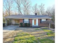 Charming brick home featuring a covered carport and manicured front yard, blending convenience with curb appeal at 1713 Elder Ct, Burlington, NC 27215