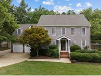 Charming two-story home featuring a manicured lawn, mature trees, and a welcoming entrance at 2001 Carrington Dr, Raleigh, NC 27615
