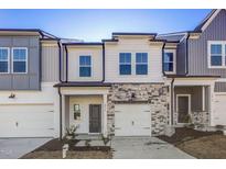 Charming two-story townhome featuring a stone facade, single-car garage, and inviting entryway at 2004 Regal Dr # 86, Durham, NC 27703