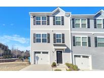 Charming two-story townhome featuring attached garage, classic black shutters, and neat front lawn landscaping at 2005 Silent Bend Dr, Durham, NC 27704