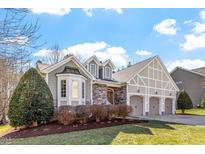 Charming home featuring stone accents, three-car garage, manicured landscaping, and beautiful architectural design at 201 Sea Biscuit Lane, Apex, NC 27539