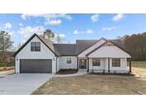 A modern, white farmhouse-style home with a gray roof, dark trim, and an attached two-car garage at 2955 Mt Pleasant Rd, Willow Springs, NC 27592