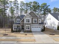 Beautiful two-story home featuring stone accents, a two-car garage, and a well-maintained front yard at 308 Harmony Creek Pl, Apex, NC 27539