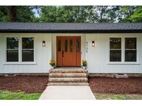 Inviting front entrance with a brick staircase and a vibrant orange door at 4705 Bernie Pl, Raleigh, NC 27616