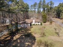 Charming single story home with a lush green yard and a backdrop of mature trees at 4800 Howe St, Durham, NC 27705