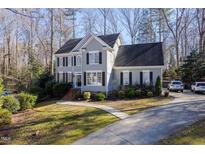 Charming two-story home featuring a well-manicured lawn and a convenient driveway in a serene, wooded setting at 4916 Brambleridge Ct, Holly Springs, NC 27540