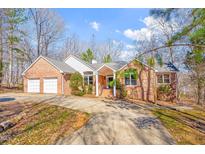 Charming brick home featuring an attached two-car garage and a well-manicured front yard at 563 Oak Crest Drive Dr, Chapel Hill, NC 27516