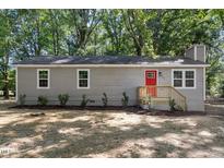 Charming one-story home with gray siding, red front door, and well-maintained landscaping at 567 Howard Tant Rd, Zebulon, NC 27597