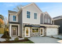 Charming two-story home featuring stone accents, mixed siding, a covered entry, and an attached two car garage at 602 Andrade Dr, Fuquay Varina, NC 27526