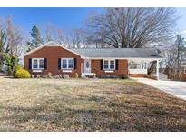 Charming red brick home with a well-maintained lawn and a covered carport for convenient parking at 634 Hillhaven Ter, Roxboro, NC 27573