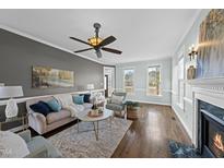 Inviting living room with fireplace, plush seating, ceiling fan, and abundant natural light at 126 Claire Dr, Clayton, NC 27520