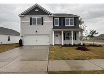 Charming two-story home with a two-car garage and professionally landscaped front yard at 150 Ethel Ln, Angier, NC 27501