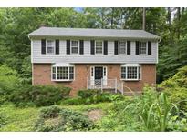 Charming two-story home with brick facade, complemented by black shutters and lush landscaping at 2004 Beecham Cir, Raleigh, NC 27607