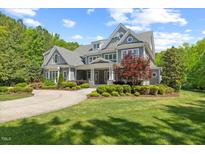 Stunning two-story home boasts manicured lawn, mature landscaping, and timeless architectural details at 219 Colvard Park Dr, Durham, NC 27713