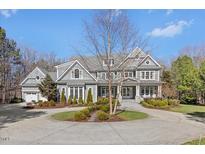 Stunning gray home with manicured landscaping and circular driveway on a sunny day at 219 Colvard Park Dr, Durham, NC 27713