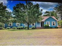 Charming single-story home with blue siding, a welcoming porch, and a lush green lawn at 22 Woodridge Ln, Cameron, NC 28326