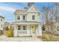 Charming two-story home with a welcoming front porch and yellow front door at 2808 W Main St, Durham, NC 27705
