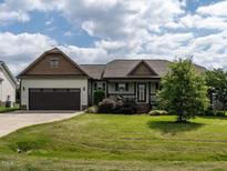 Charming single-story home with a well-manicured lawn, attached garage and inviting front entrance at 30 Imperial Dr, Clayton, NC 27527