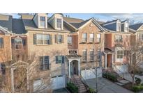 Charming brick townhome featuring detailed architectural elements and manicured landscaping in an inviting neighborhood at 3003 Weston Green Loop, Cary, NC 27513
