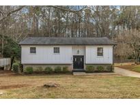 Charming home with a well-maintained lawn, complemented by lush greenery and a double door entry at 305 November St, Garner, NC 27529