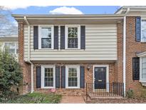 Charming townhouse exterior with brick facade, black shutters, and inviting front entrance at 318 Mccauley St # 2, Chapel Hill, NC 27516