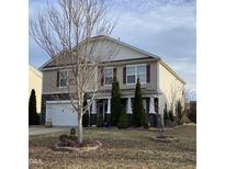 Charming two-story home features a stone facade, red shutters, a well-manicured lawn, and a two-car garage at 401 Lawton Dr, Haw River, NC 27258