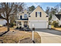 Charming two-story home with a manicured lawn and attached two-car garage at 405 Braxman Ln, Holly Springs, NC 27540