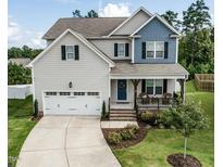 Charming two-story home featuring a two-car garage, inviting front porch, and well-manicured lawn at 50 Dover Ridge Ct, Chapel Hill, NC 27517