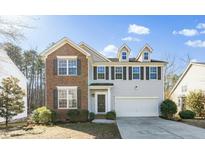 Charming two-story home featuring a brick facade, gray siding, and a two-car garage at 6715 Winding Arch Dr, Durham, NC 27713