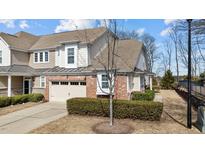 Charming townhome with a brick-accented garage, beige siding, and well-manicured landscaping at 8311 Yaxley Hall Dr, Raleigh, NC 27616