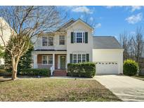 Charming two-story home with a manicured lawn, inviting front porch, and a two-car garage at 938 Widewaters Pkwy, Knightdale, NC 27545