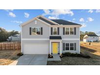 Charming two-story home features gray siding, a bright yellow front door, and an attached two-car garage at 95 Westbrook Ln, Franklinton, NC 27525