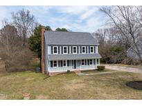 Charming two-story home with blue siding, black shutters, brick chimney, and inviting front porch at 108 Meadows Cir, Knightdale, NC 27545