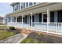 Charming blue home with a welcoming front porch, white railings, and black shutters at 108 Meadows Cir, Knightdale, NC 27545