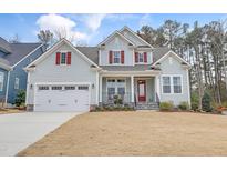 Charming two-story home featuring light blue siding, red shutters, front porch, and an attached two-car garage at 1129 Sequoia Creek Ln, Cary, NC 27519