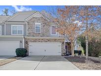 Charming townhome featuring a stone facade, two-car garage, and well-maintained landscaping at 146 Skyros Loop, Cary, NC 27519