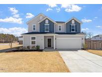 Two-story home with a two-car garage and a well-maintained lawn in a suburban neighborhood at 171 Piney Field Rd, Fuquay Varina, NC 27526