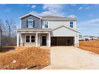 New two-story home with blue and gray siding and an attached two-car garage in a construction zone at 1745 Pie Filling Dr, Haw River, NC 27258